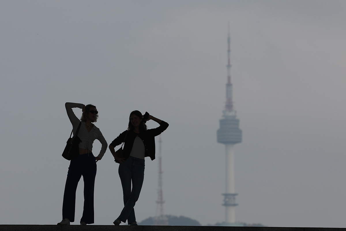 Two foreign visitors to the National Museum of Korea in Seoul's Yongsan-gu District on the morning of Oct. 28 take a photo with N (formerly Namsan) Seoul Tower in the background amid mostly foggy weather nationwide.